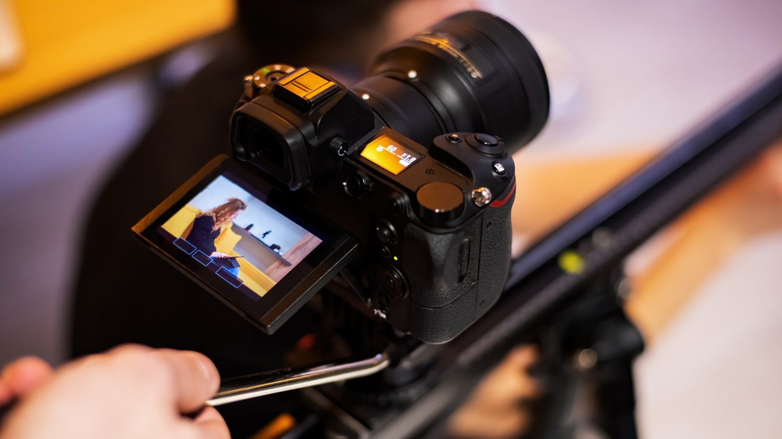 Close-up of a camera recording an interview, with a woman visible on its monitor